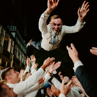 groom being thrown into the air by his fellow rugby team wedding guests during a kent wedding reception