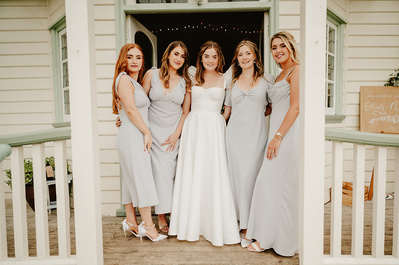 Bridesmaids and Bride pose on the steps of beacon house for a photo