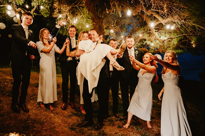 Sparkler sendoff of a difference with Groom holding Bride in his arms