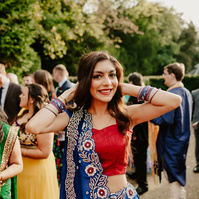 a bridesmaid wearing colourful clothing smiling for the camera at the kent wedding venue hayne house