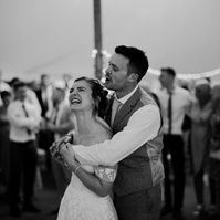 a black and white photo of a kent bride and groom standing in the middle of a teepee dance floor in total love and enjoyment during their reception