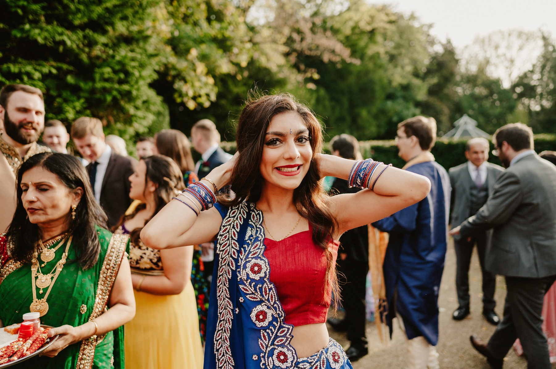 a bridesmaid wearing colourful clothing smiling for the camera at the kent wedding venue hayne house