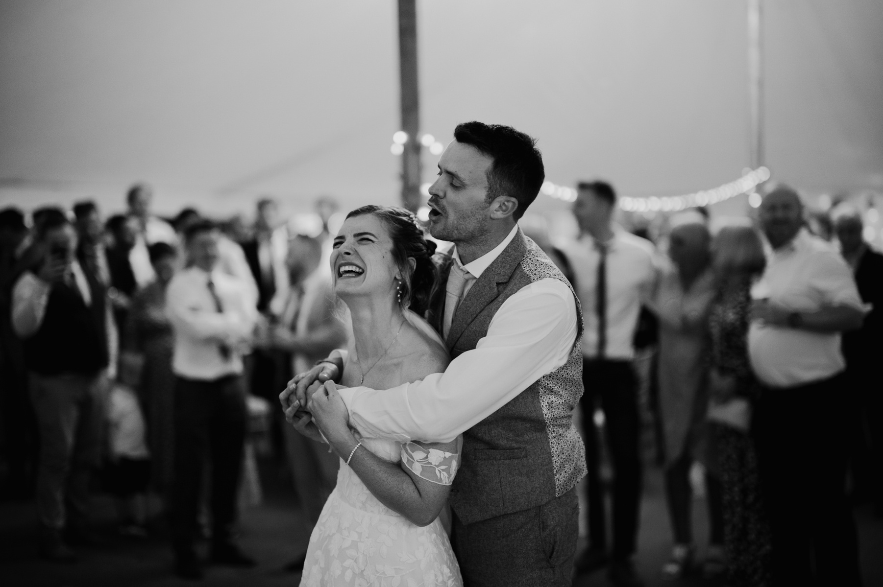 a black and white photo of a kent bride and groom standing in the middle of a teepee dance floor in total love and enjoyment during their reception