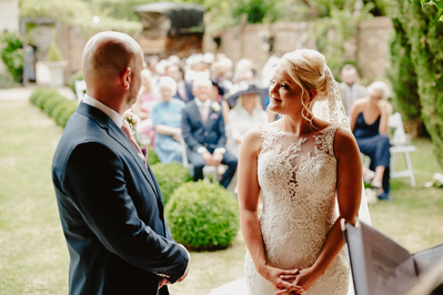 Bride looks upon her groom lovingly during ceremony at Marleybrook House