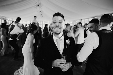 Black and white photo at the night yard with the best man smiling at the camera