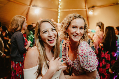 Two female women guess on the dancefloor pose for a photograph