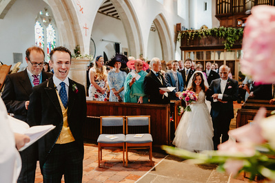 Photo inside a church in Kent with Bride and her father walking down the aisle to her groom