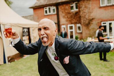 Kent garden wedding guest posing funnily for the camera whilst holding a drink