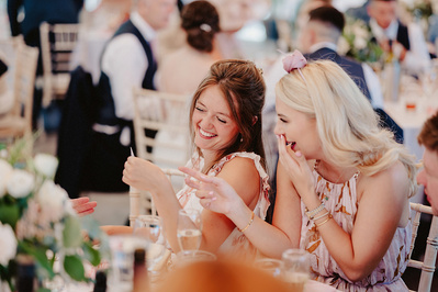 Wedding guests laughing during the speeches at the night yard