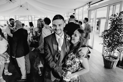 candid photo of 2 people laughing on the night yard dance floor in black and white