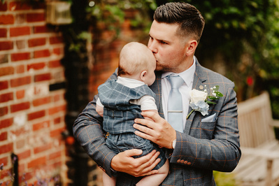 groom kisses his child emotionally