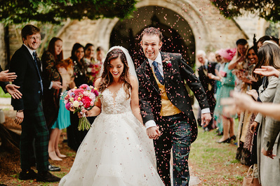 confetti being thrown on the bride and groom as they walk out of the church in Kent
