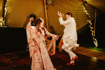 Photo of bride and groom wearing traditional Indian clothes dancing on the Dancefloor in Kent