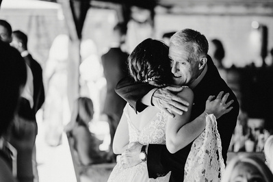 Black and white photo of Bride hugging wedding guest at the night yard