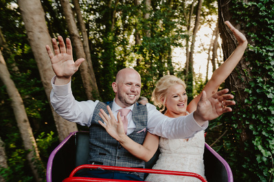 Bride and groom on a really fast rollercoaster with their hands in the air at Marleybrook House