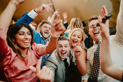 Wedding guests all cheer for the camera during the chaotic dancefloor in Kent
