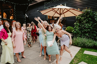 female wedding guests in chaos during the flower toss at winters barns