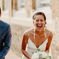 couple laugh together in lovely golden light with bricks in the background in margate during seaside kent wedding