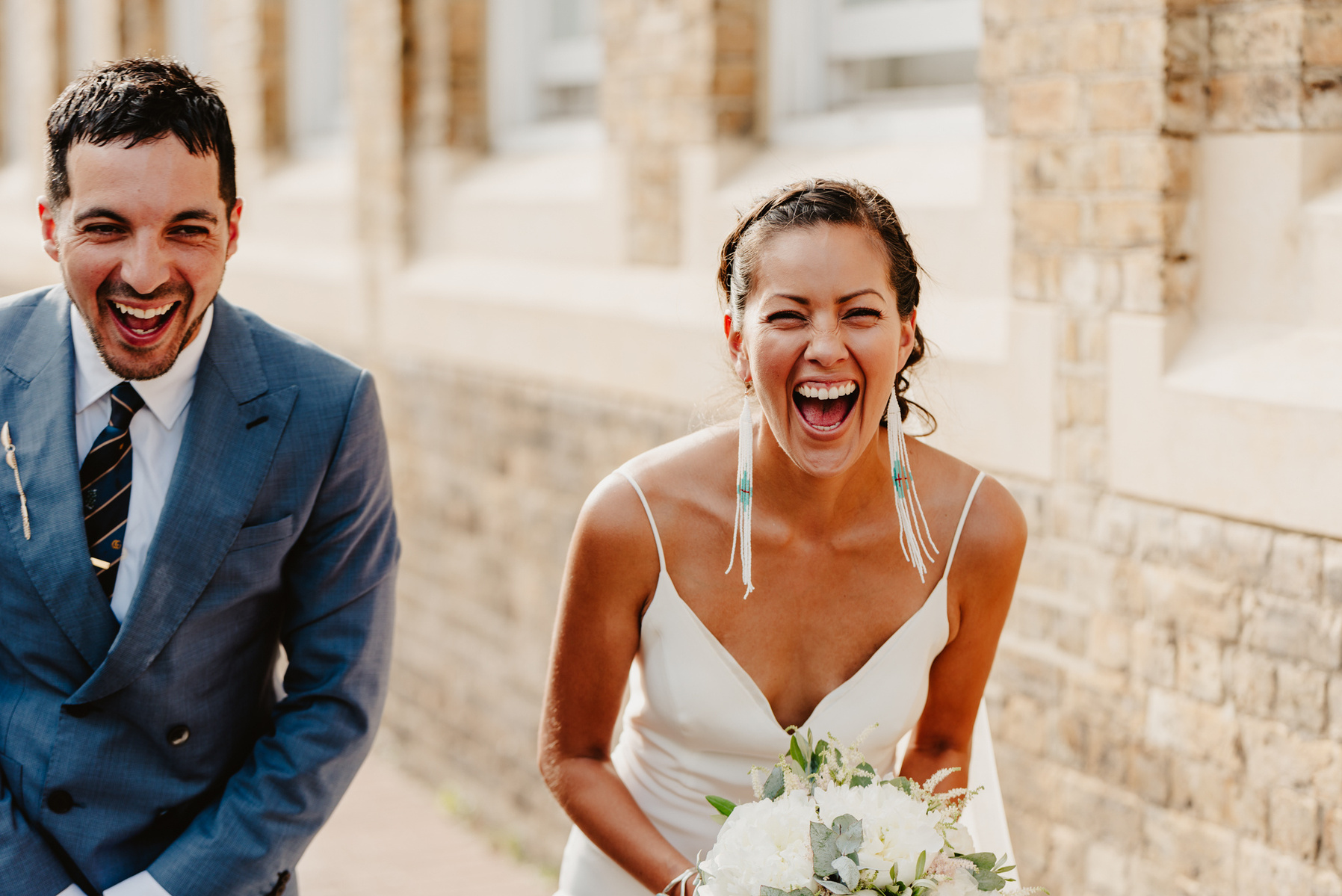 couple laugh together in lovely golden light with bricks in the background in margate during seaside kent wedding