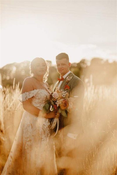 beautiful golden hour portrait of married couple in a long grass field at silchester farm