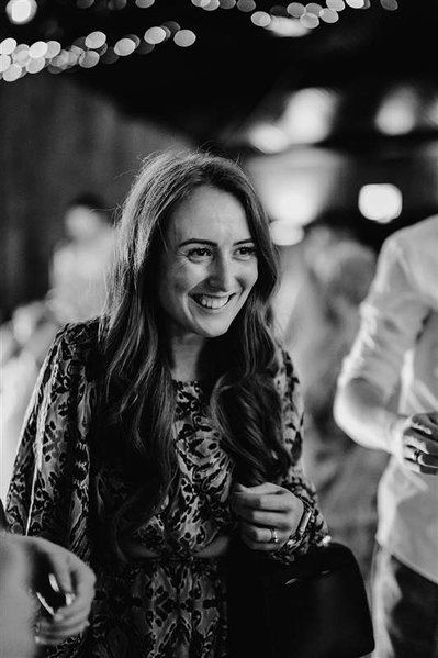 candid photo of wedding guest smiling during the wedding reception in black and white