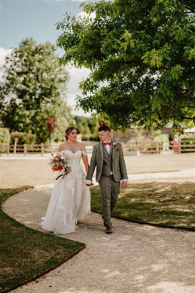 bride and groom walking along a path outdoors at silchester farm