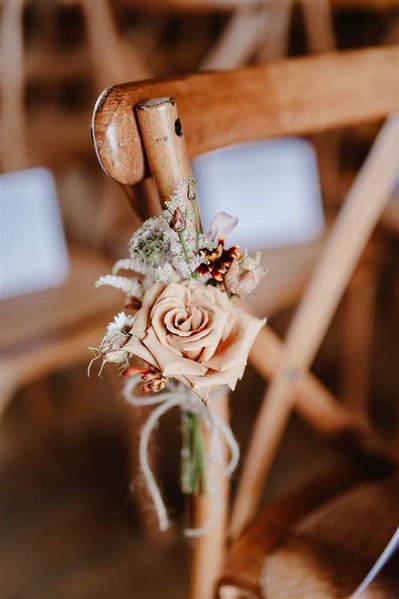 a single rose on a wooden chair at the wedding venue silchester farm