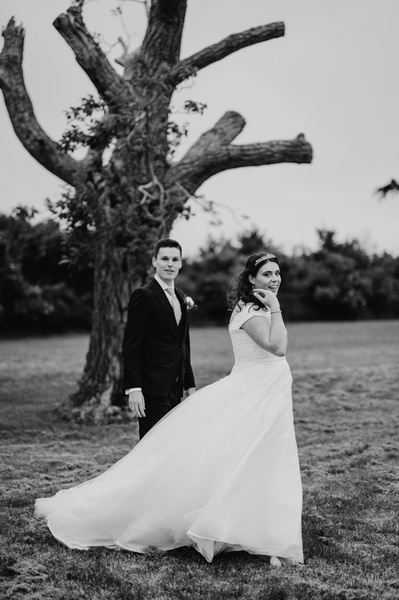 Dramatic windy wedding portrait at Chapel house estate, standing in front of a tree in black and white