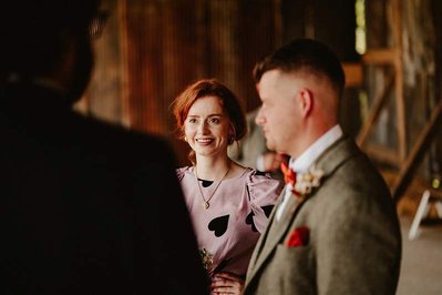 natural portrait of a wedding guest smiling in soft warm light