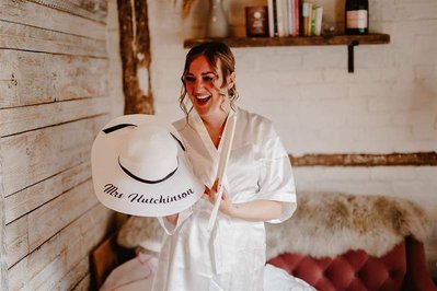 beautiful bride on her wedding day laughing at her new gift at silchester farm