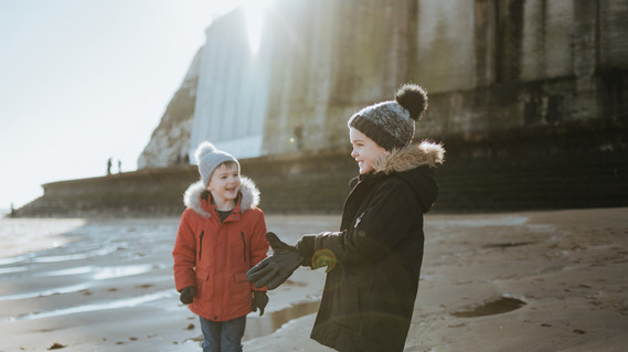 kids playing on a thanet beach with a shallow depth of field lens flare