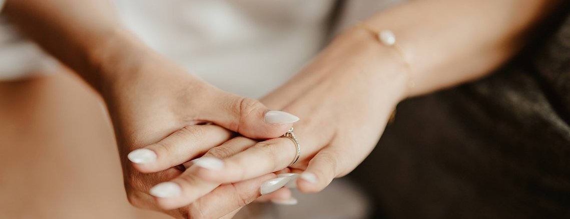 a hand holding an engagement ring