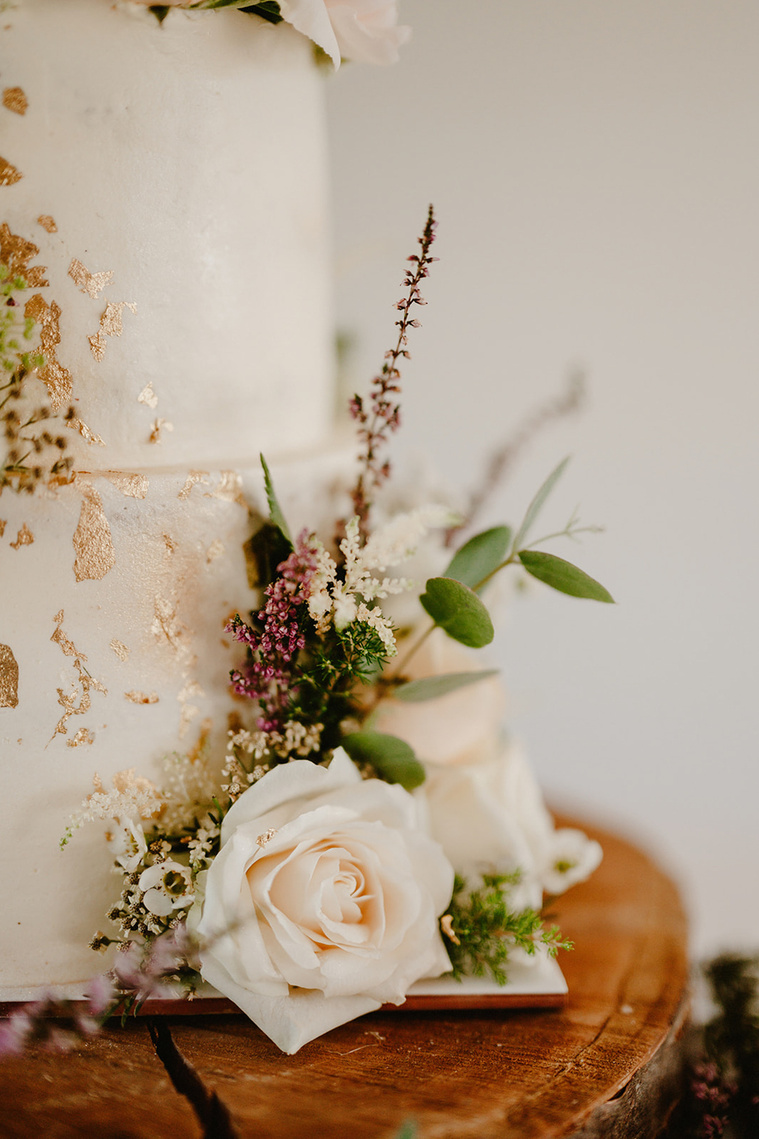 gold coated white wedding cake with a flower at the yalding kent