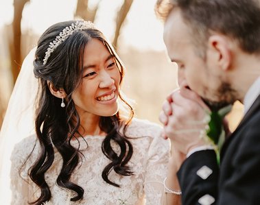 groom warms up brides hands during cold golden hour during wedding day