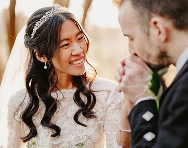 groom romantically warming up his brides hands in the cold during winter golden hour