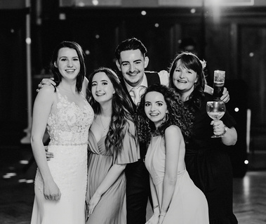 black and white photo of friends together on the dance floor smiling at the camera