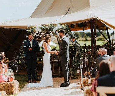 bride and groom getting married in the teepee in a outside ceremony at Lillyroos glamping in Sandwich it is one of the best wedding venues in Kent