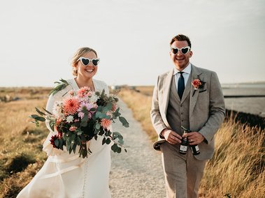 Fun loving couple on their wedding day wearing heart shaped glasses during wedding photography