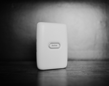 a black and white product photo of the fujifim instax mini printer on a shelf for wedding photography