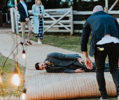 Wedding Guest being rolled up in a carpet in a silly moment shows the fun to be had at wedding venues in kent