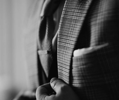 wedding photography of a groom checked suit in black and white and tie clip