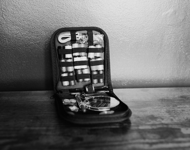 a black and white product photo of an emergency sewing kit on a shelf
