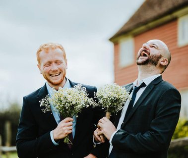 Wedding guests laughing their heads off outside at Kent life after the ceremony