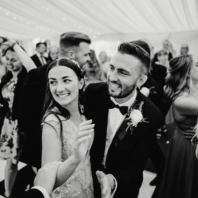 black and white photo of bride and groom smiling candidly on the dance floor at cave hotel kent