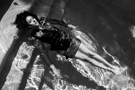 the French actress Vanessa guide in a Balmain dress, floating in a swimming pool in Los Angeles
