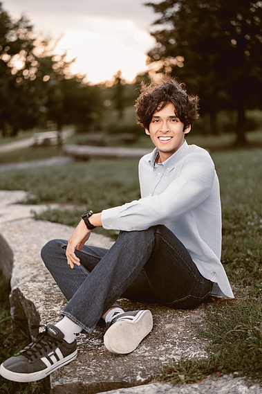 A high school boy's senior portrait featuring a stunning sunset in Mequon, Wisconsin. The serene ambiance and the beautiful evening light make this photo a perfect representation of senior year. 