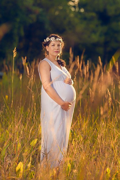 Elegant outdoor maternity session in Mequon, Wisconsin, featuring an expectant mother in a beautiful dress. Capturing the special moments of pregnancy in a picturesque natural setting. 