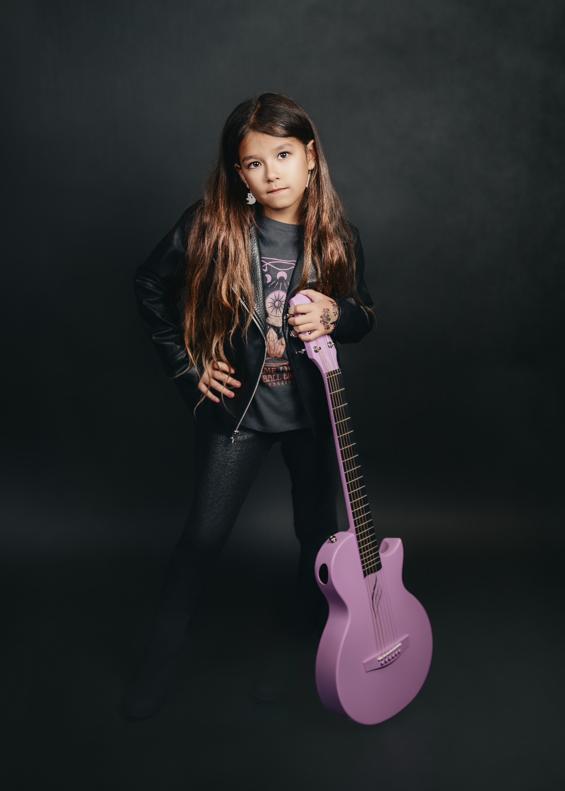 Cute girl poses with her new pink guitar at the studio in Mequon Wisconsin. A beautiful child portrait photography.