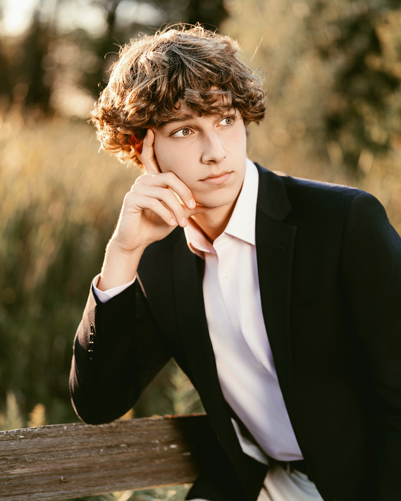 Stunning outdoor portrait of  a high school boy taken in Virmond Park in Mequon, WI. This image captures his confident smile against a vibrant natural backdrop, showcasing the beauty of the local scenery. 
