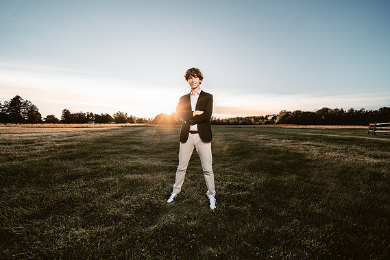Dynamic senior portrait featuring a high school boy posed in a picturesque park in Mequon, Wisconsin. The image showcases his personality and enthusiasm for future. 